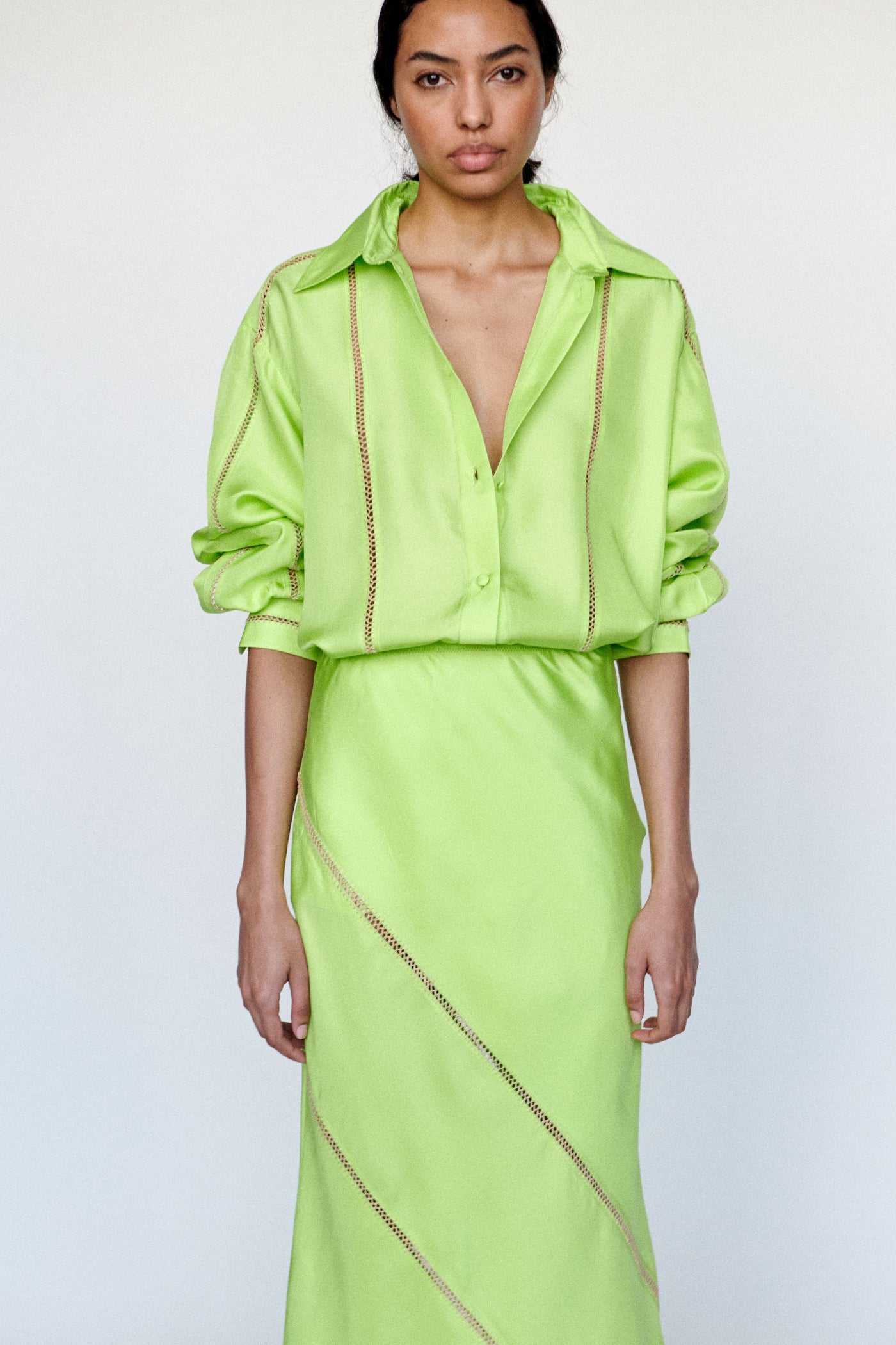 Light lime green skirt with diagonal a natural cream colored stitching on a white background