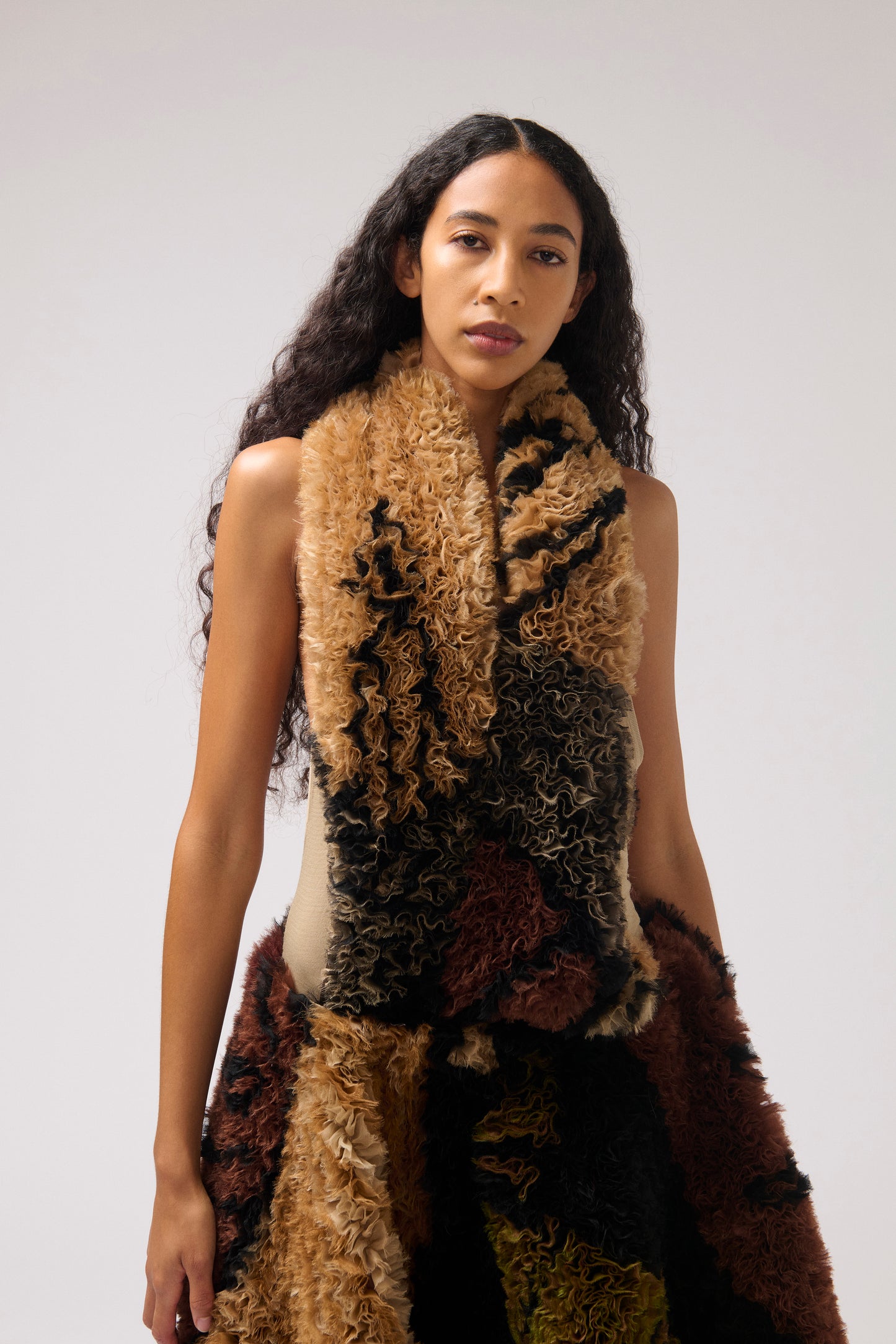 A brown and beige printed organza dress with a halter neckline, photographed worn by a model looking at the camera.