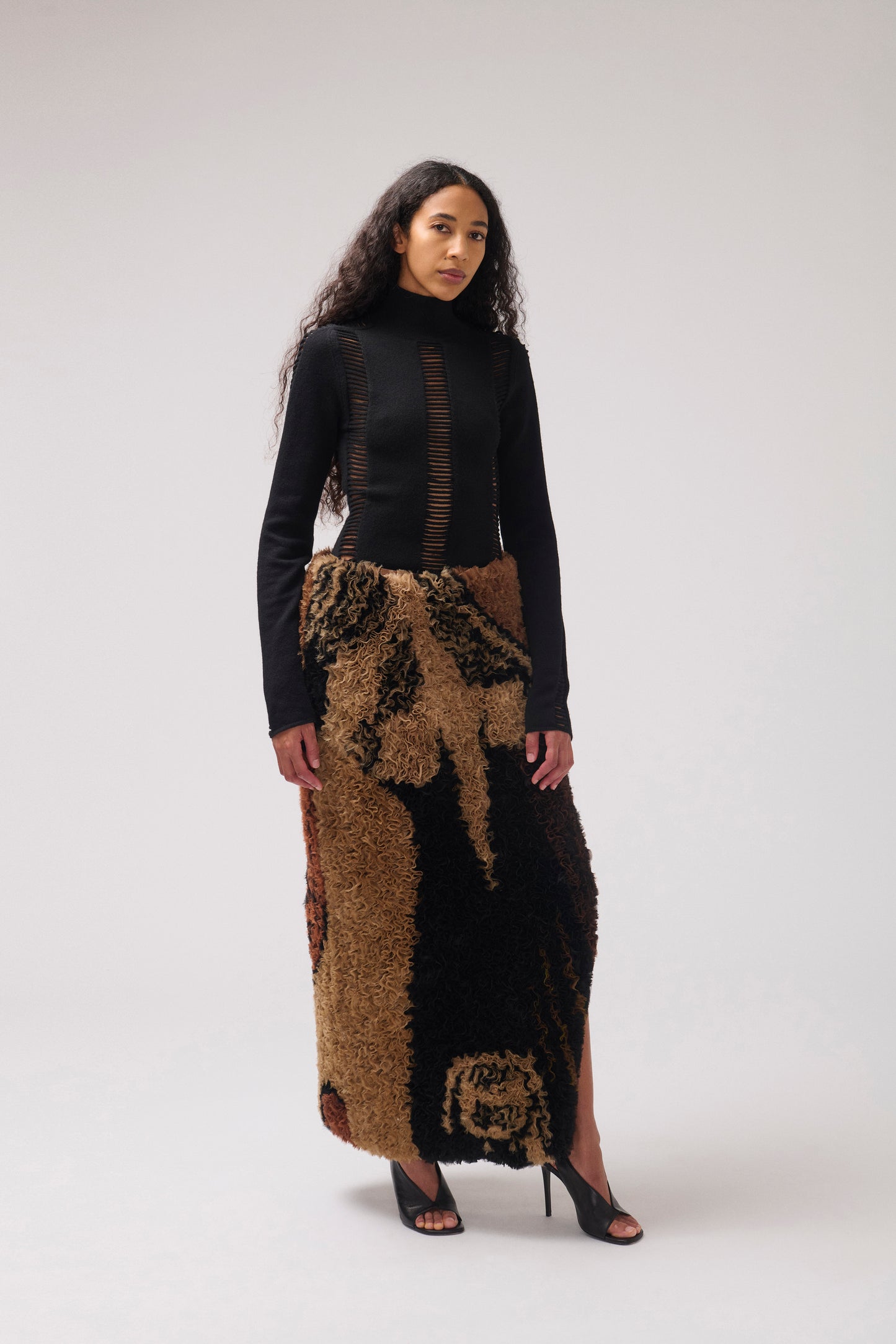 A model wearing ruffled organza striaght skirt with a dark brown and black abstract pattern, shown flat against a solid white background.