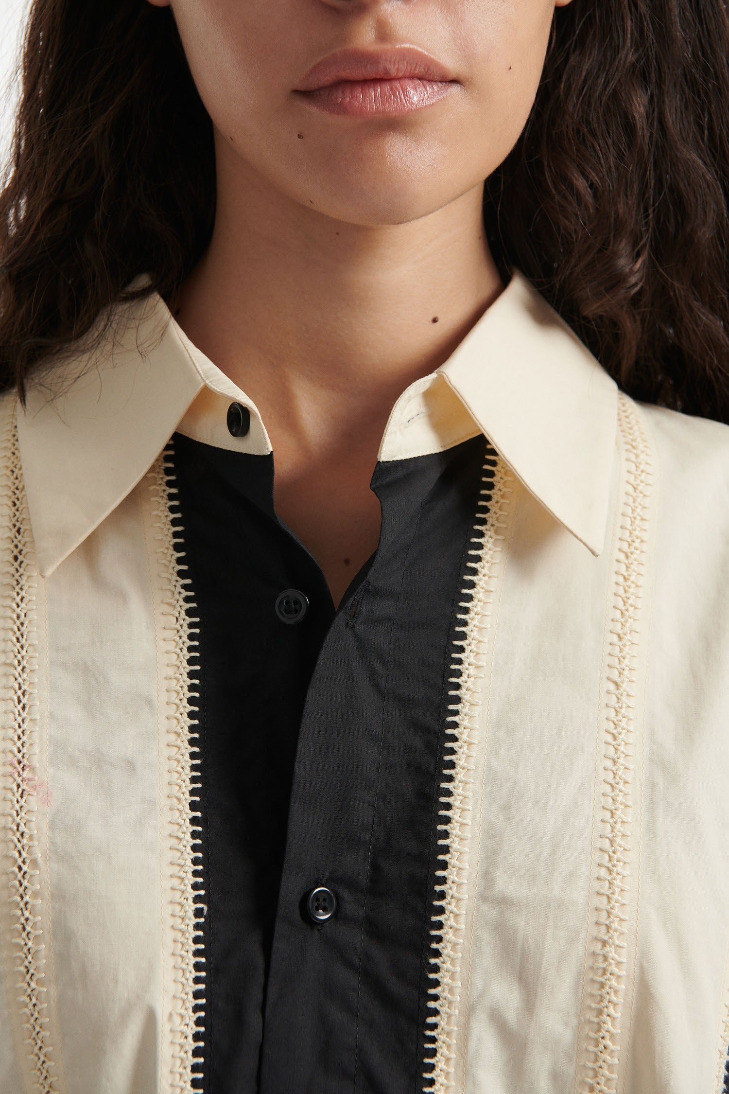 Female model wears off-white and black vertical striped panel button down shirt with cotton black pants and black high heel boots on white background. 