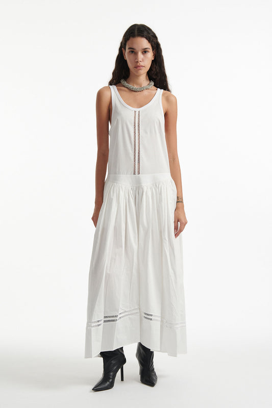 Female model wears white poplin sleeveless dress with cutout stitched detailing and black high heels on white background. 