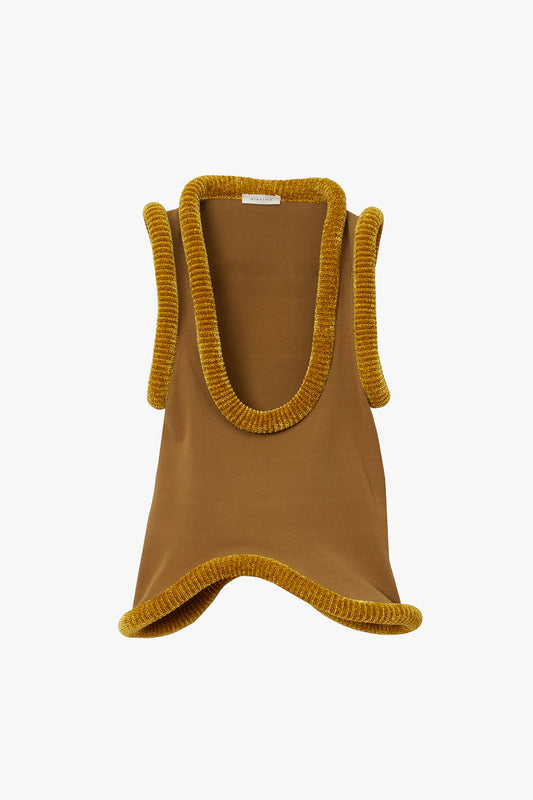 Yellow-brown flat knit tank top with mustard yellow sculptural tubing at hem photographed on a white background. Tank has scooped "U" shaped neckline and wavy bottom hem. 