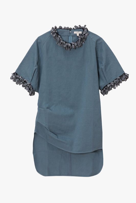 Blue shirt with paillette trim details on a white background