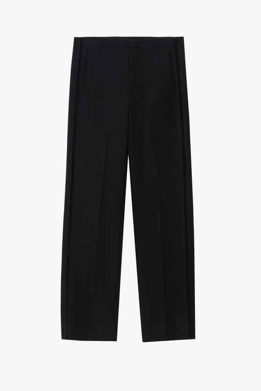 Flat image of a black wool pant with a vertical stitched detail. The pants are pictured against a plain light gray background