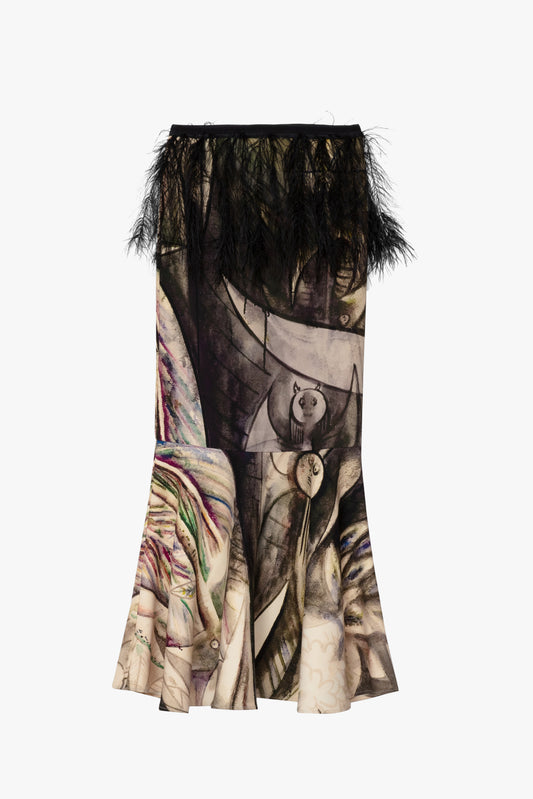 A long, flared skirt featuring a surreal collage print with abstract faces, feathers, and organic shapes in beige, brown, black, and muted pink tones, finished with a black feathered hem against a plain white background.