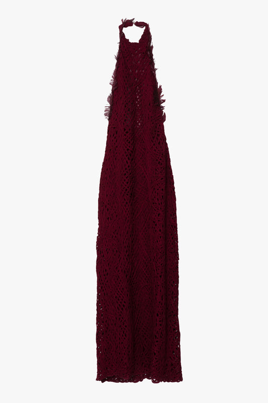A burgundy dress shown against a white background. The dress is a textured halter gown in a deep burgundy color. The dress features burgundy feather details and a large open back.