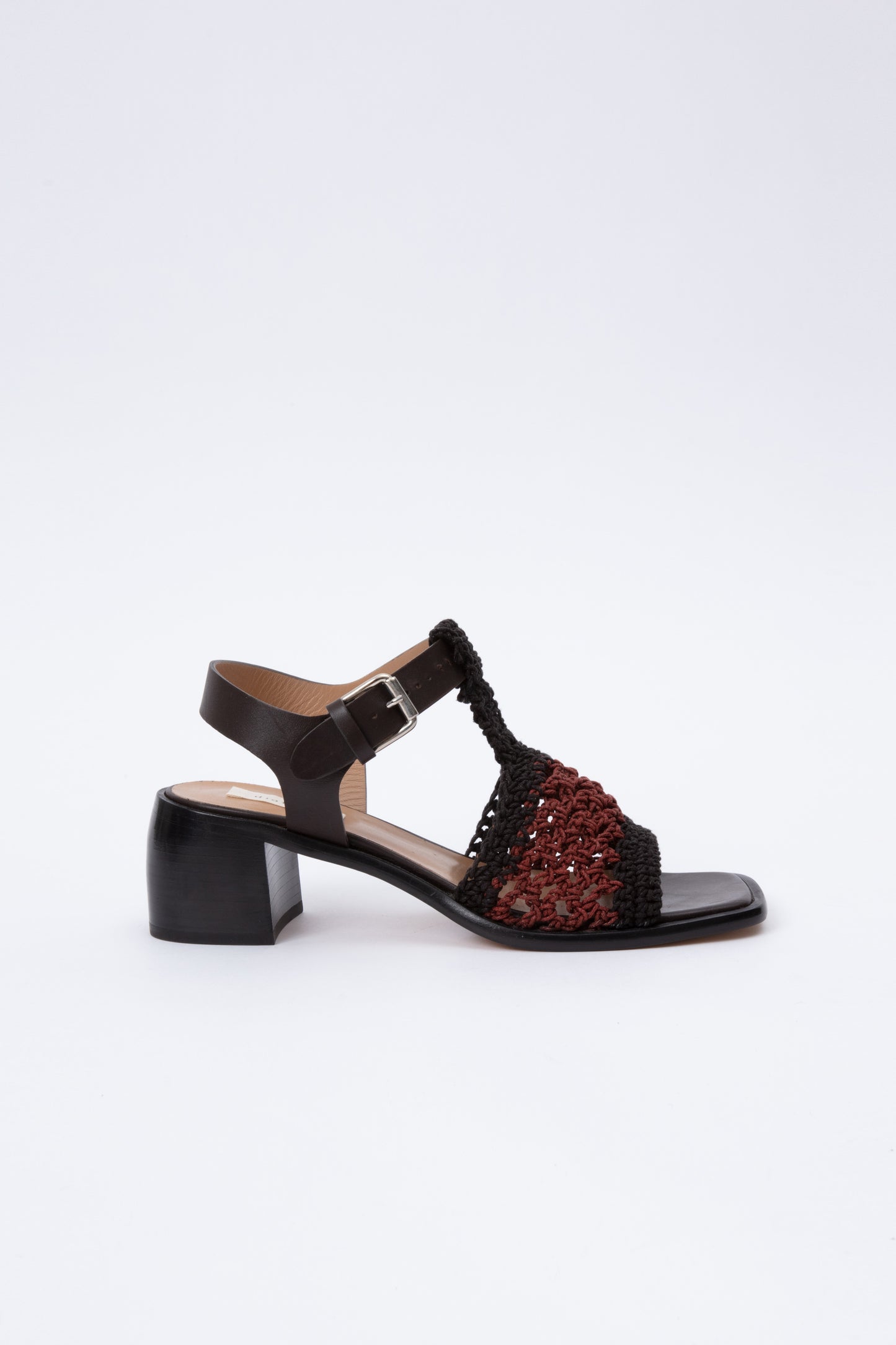 Open toe sandals with black leather base and ankle straps. The block heel is slightly rounded and thick. Connected to the ankle strap is a toe strap made from hand-knit crochet in black and maroon. 