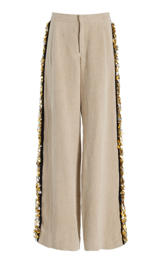 Beige pants with decorative side silver and gold palette trim on a white background