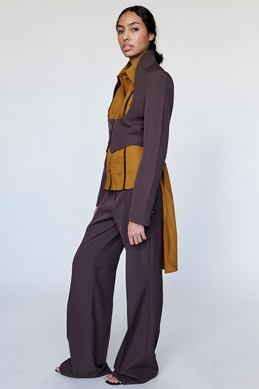 Woman wearing a brown and mustard outfit on a white background